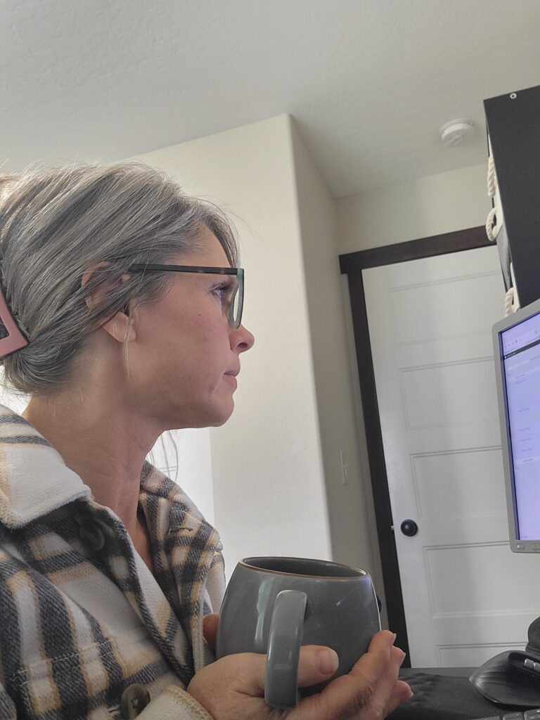 Erin Palmer sitting at her computer, viewed from the side, working in her office.