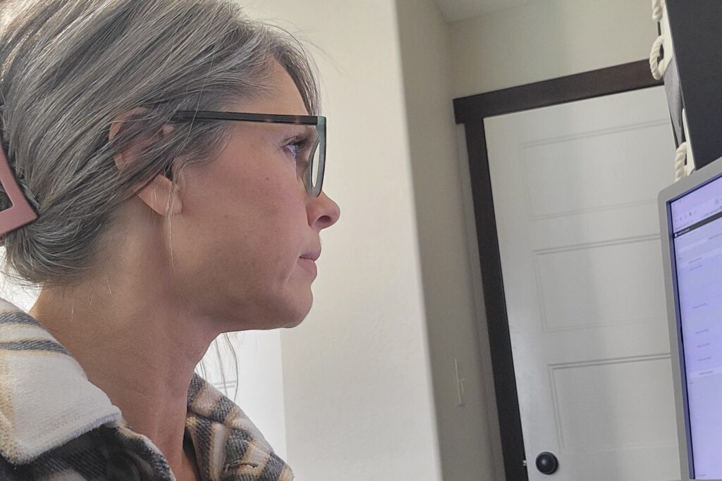 Erin Palmer working at her computer, viewed from the side in her office.